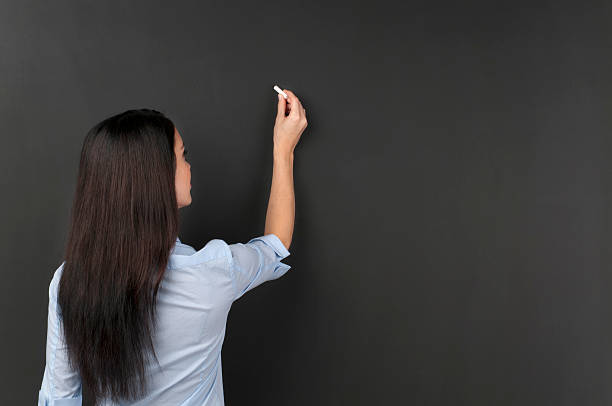 Student writing on blackboard